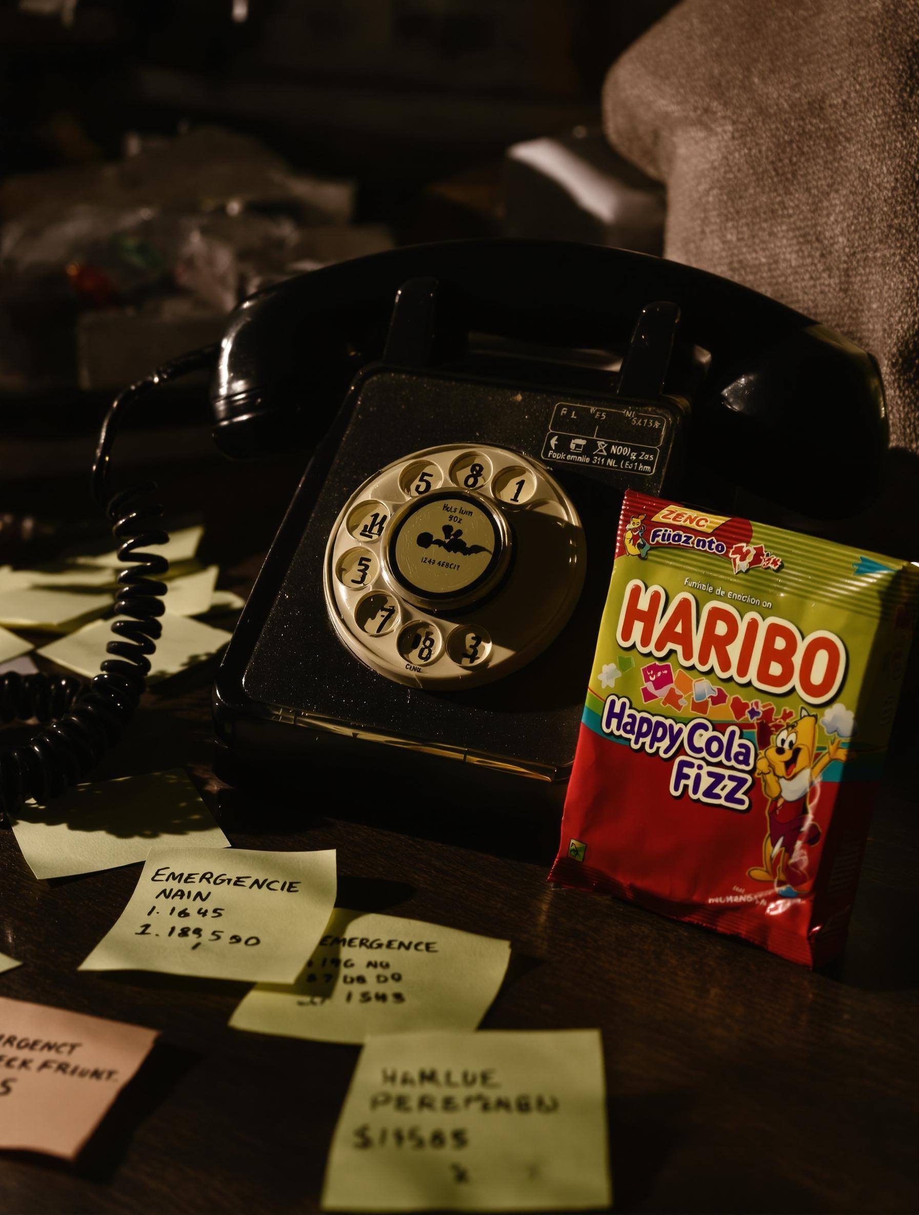 Téléphone vintage avec post-it des numéros d’urgence pour Haribo Happy Cola Fizz